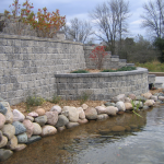 Steep stone brick retaining wall by water installer for Ozaukee County
